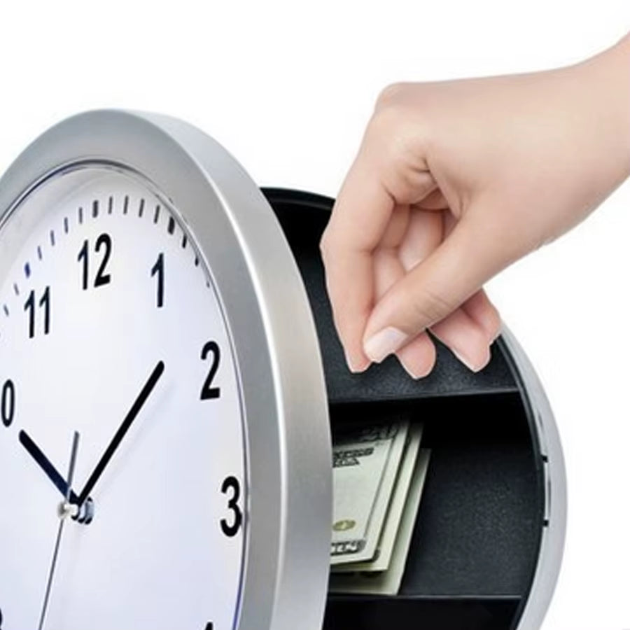 Une main range des billets dans l’espace de stockage caché d’une horloge murale coffre-fort