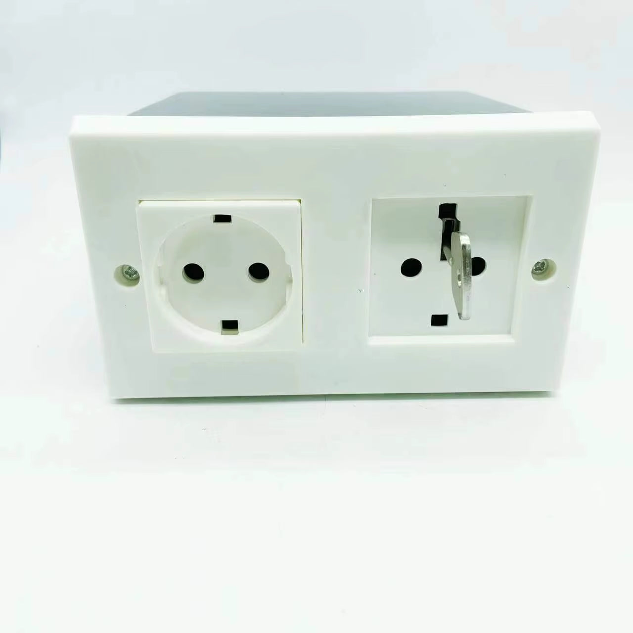 Prise murale factice double avec compartiment secret et clé insérée dans l’ouverture de sécurité

